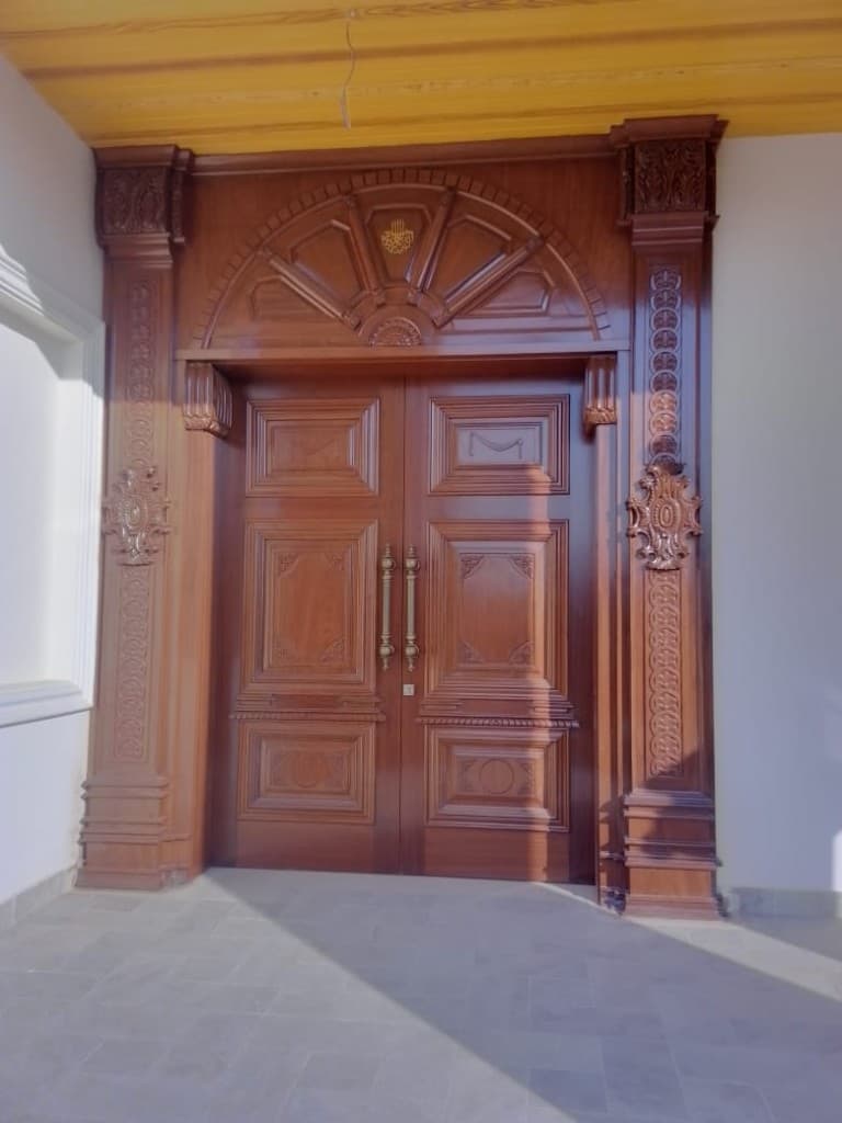 Ornate double doors with carved frame and arched transom