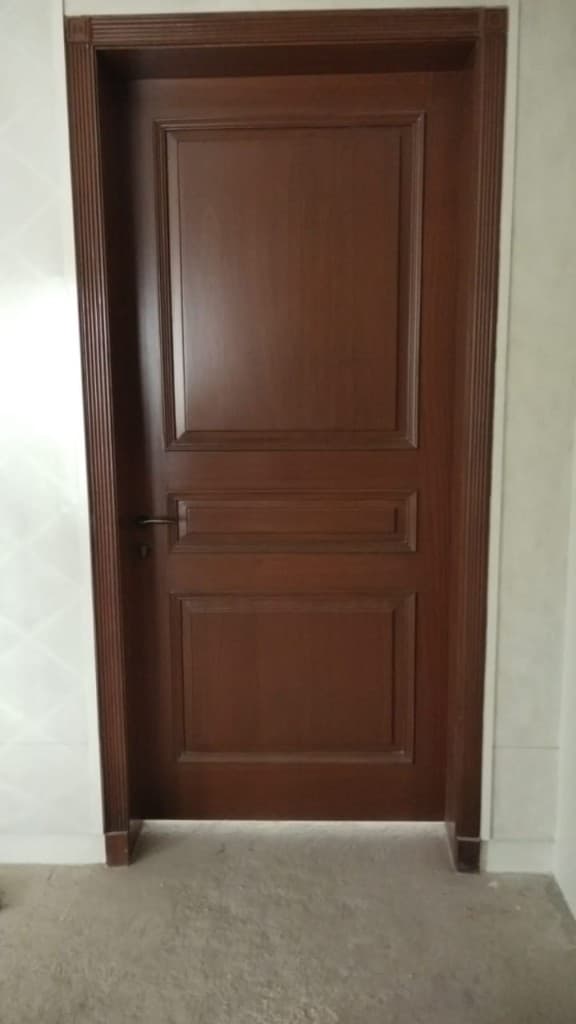 Classic three-panel dark wood door with fluted frame