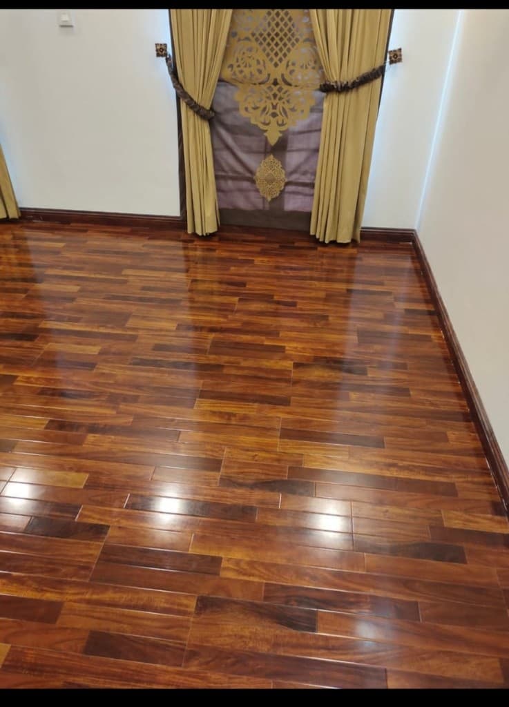 Empty room with glossy multi-tone amber wood flooring