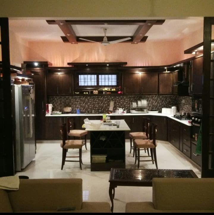 Dark wood U-shaped kitchen with island and mosaic backsplash