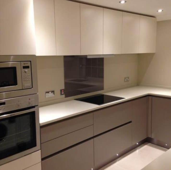 Minimalist two-tone handleless kitchen with built-in oven stack
