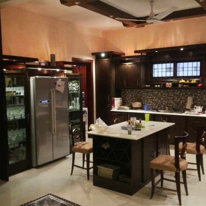 Dark wood kitchen island with wine rack and glass display cabinets