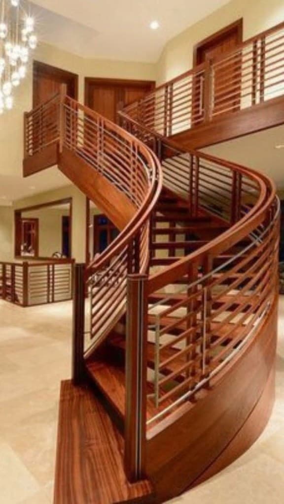 Curved mahogany staircase with horizontal wood slat railing