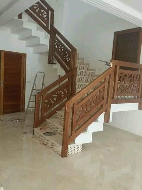 Two-flight staircase with carved wooden geometric railing panels